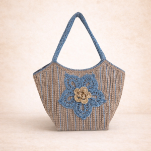 "Bolso Arena & Lirios de Amaro Crochet: bolso de mano tejido 100% a mano en tonos tierra y azul con aplicación de flor 3D en relieve."