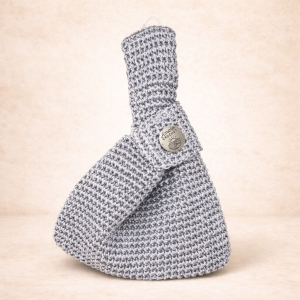 Bolso Luz Serena de autor en crochet tejido a mano, diseño japonés minimalista en cintilla satinada plata, vista frontal.